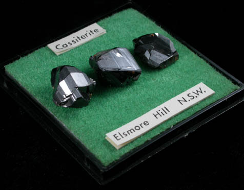 Cassiterite (three mounted crystals) from Elsmore Hill, New South Wales, Australia