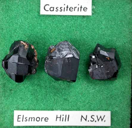 Cassiterite (three mounted crystals) from Elsmore Hill, New South Wales, Australia