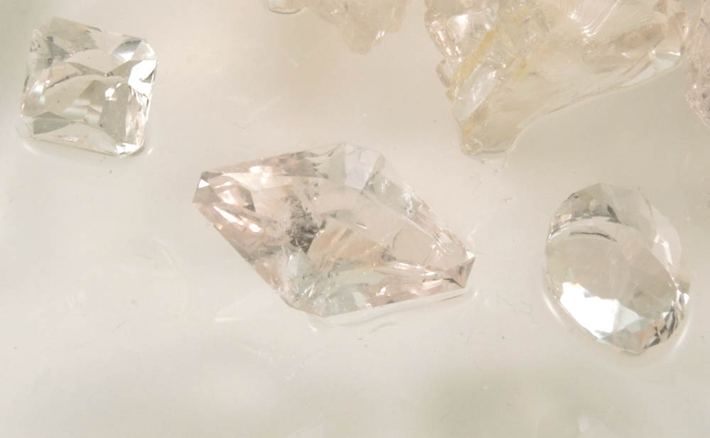 Beryl var. Morganite (three faceted gemstones totaling 5.53 carats with rough) from Haddam Neck, Middlesex County, Connecticut