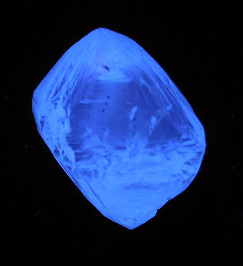 Photo below under longwave ultraviolet illumination of Diamond (4 carat cuttable pale-yellow octahedral diamond) from Mirny, Sakha Republic, Siberia, Russia Diamond (4 carat cuttable pale-yellow octahedral diamond) from Mirny, Sakha Republic, Siberia, Russia