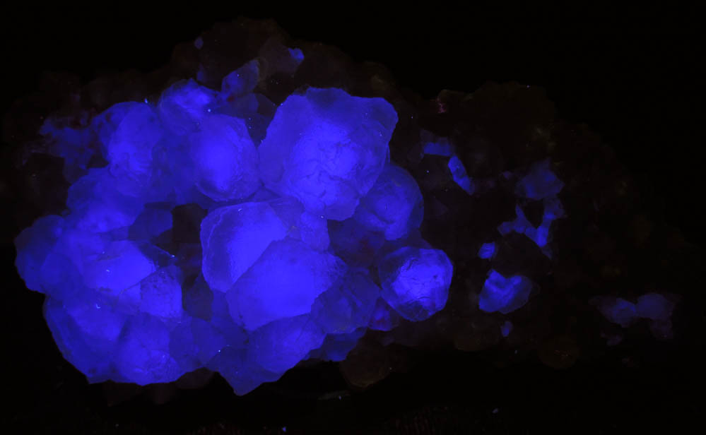 Photo below under shortwave ultraviolet illumination of Fluorite on Quartz from Peaked Mountain, east of North Conway, Carroll County, New Hampshire Fluorite on Quartz from Peaked Mountain, east of North Conway, Carroll County, New Hampshire