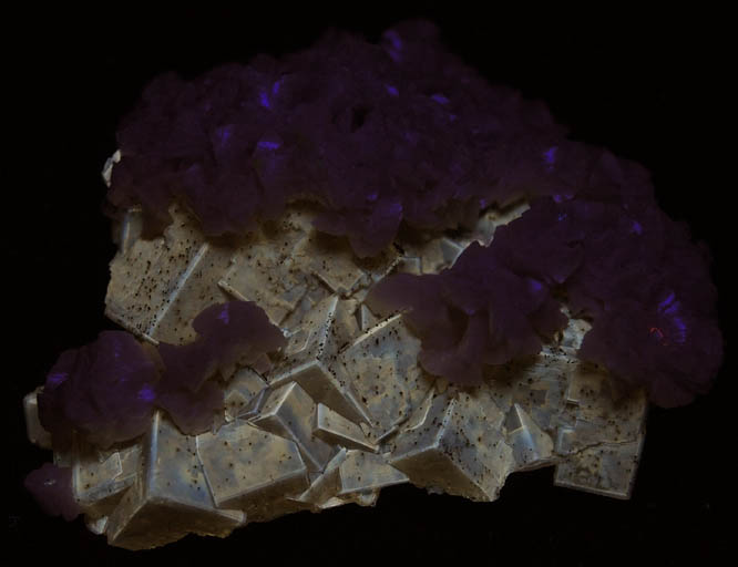 Photo below under shortwave ultraviolet illumination of Dolomite over Fluorite from Moscona Mine, Villabona District, Asturias, Spain Dolomite over Fluorite from Moscona Mine, Villabona District, Asturias, Spain