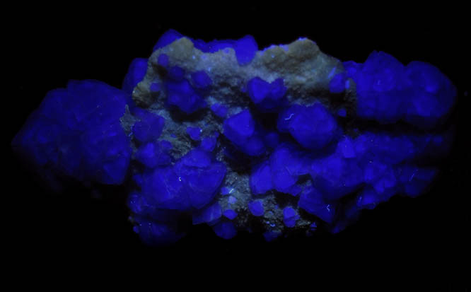 Photo below under longwave ultraviolet illumination of Fluorite on Quartz from Judith Lynn Claim, Pine Canyon, Grant County, New Mexico Fluorite on Quartz from Judith Lynn Claim, Pine Canyon, Grant County, New Mexico