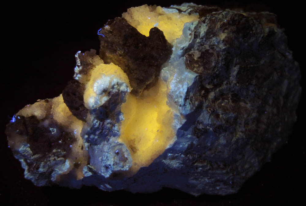Photo below under longwave ultraviolet illumination of Hydrozincite with Hemimorphite from Yellow Pine Mine, Goodsprings District, Clark County, Nevada Hydrozincite with Hemimorphite from Yellow Pine Mine, Goodsprings District, Clark County, Nevada