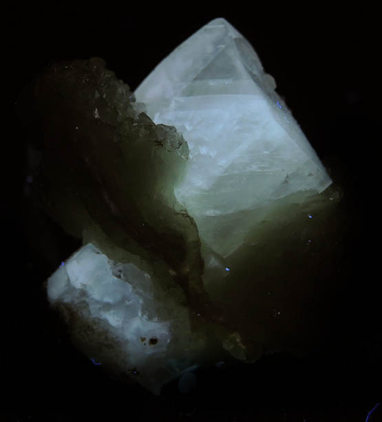 Photo below under longwave ultraviolet illumination of Calcite and Apophyllite on Prehnite from Millington Quarry, Bernards Township, Somerset County, New Jersey Calcite and Apophyllite on Prehnite from Millington Quarry, Bernards Township, Somerset County, New Jersey
