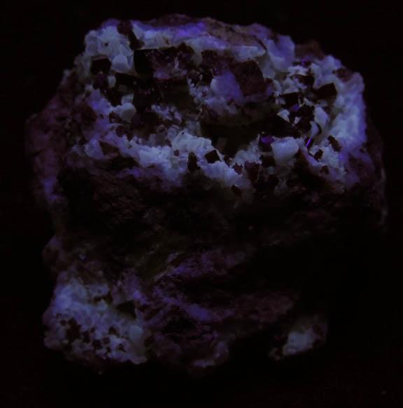 Photo below under shortwave ultraviolet illumination of Vanadinite on Calcite from Apex Mine, San Carlos, Manuel Benavides, Chihuahua, Mexico Vanadinite on Calcite from Apex Mine, San Carlos, Manuel Benavides, Chihuahua, Mexico