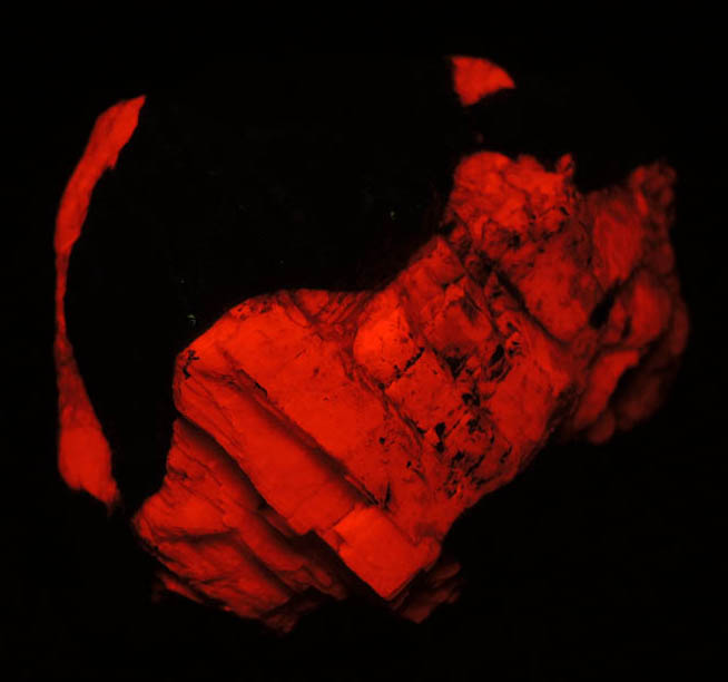 Photo below under shortwave ultraviolet illumination of Zincite in Calcite from Franklin Mine, Sussex County, New Jersey (Type Locality for Zincite) Zincite in Calcite from Franklin Mine, Sussex County, New Jersey (Type Locality for Zincite)