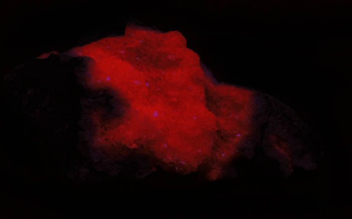 Photo below under shortwave ultraviolet illumination of Rhodochrosite from N'Chwaning II Mine, Kalahari Manganese Field, Northern Cape Province, South Africa Rhodochrosite from N'Chwaning II Mine, Kalahari Manganese Field, Northern Cape Province, South Africa
