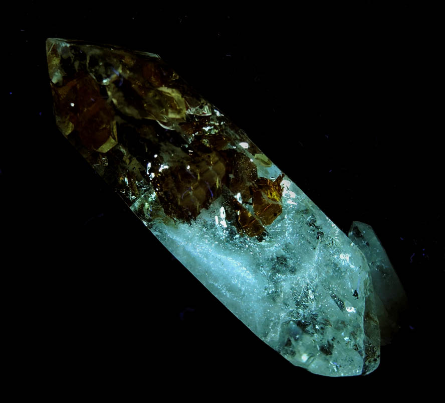 Photo below under longwave ultraviolet illumination of Quartz var. Firefly Quartz with large moveable bubble in petroleum-filled cavity from Madirobe, Tsaratanāna, Betsiboka, Madagascar Quartz var. Firefly Quartz with large moveable bubble in petroleum-filled cavity from Madirobe, Tsaratanāna, Betsiboka, Madagascar