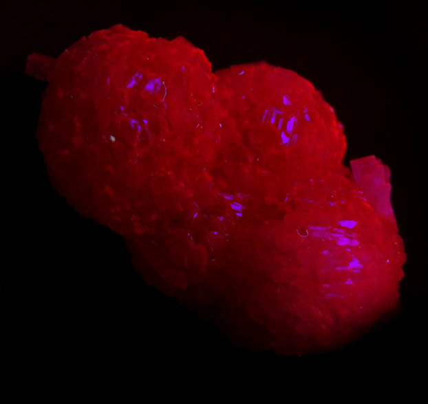 Photo below under shortwave ultraviolet illumination of Olmiite from N'Chwaning II Mine, Kalahari Manganese Field, Northern Cape Province, South Africa (Type Locality for Olmiite) Olmiite from N'Chwaning II Mine, Kalahari Manganese Field, Northern Cape Province, South Africa (Type Locality for Olmiite)